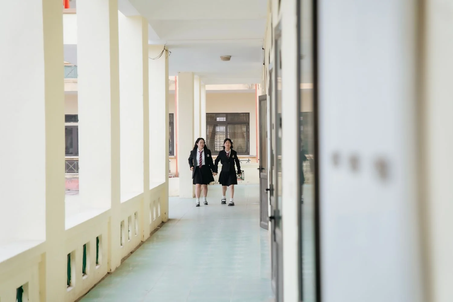 Students walking together through a bright school corridor in uniform
