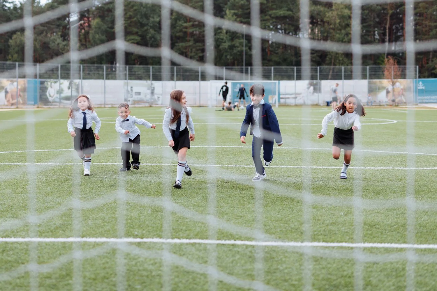Schoolchildren running together on a sports field